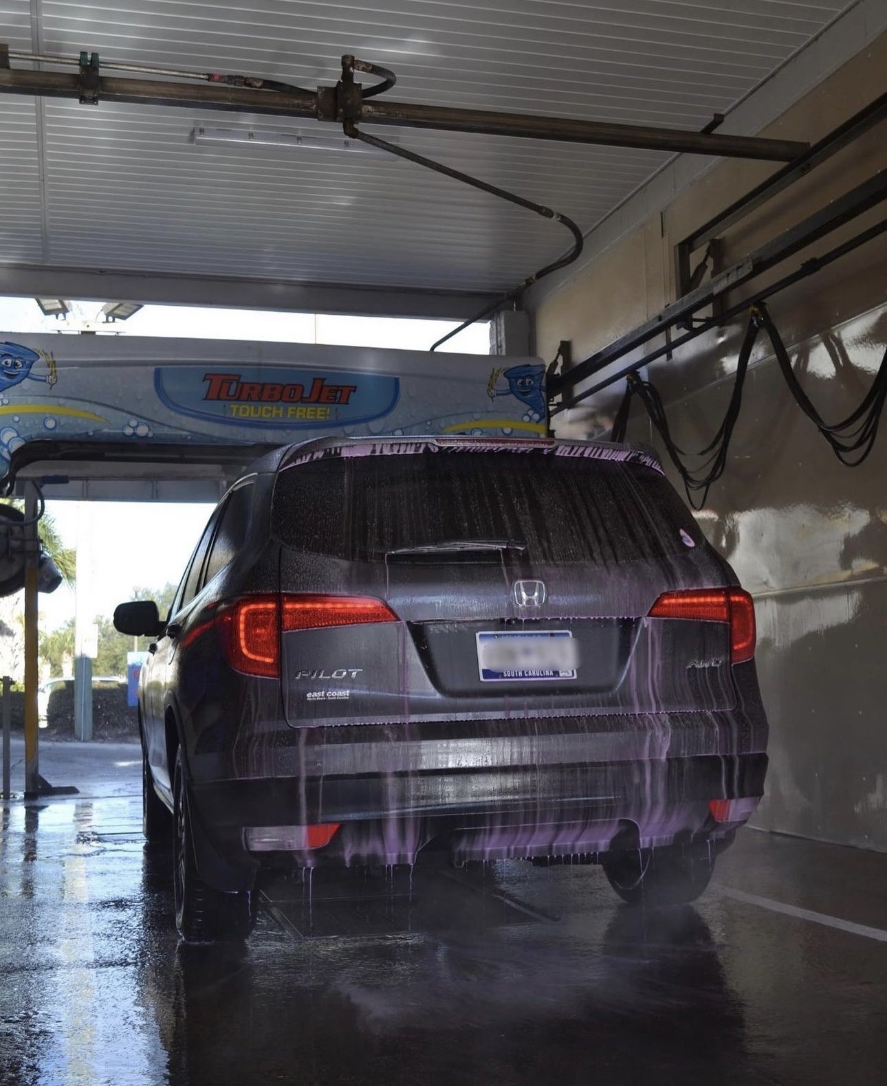 A vehicle covered in wash solution during a touch-free wash